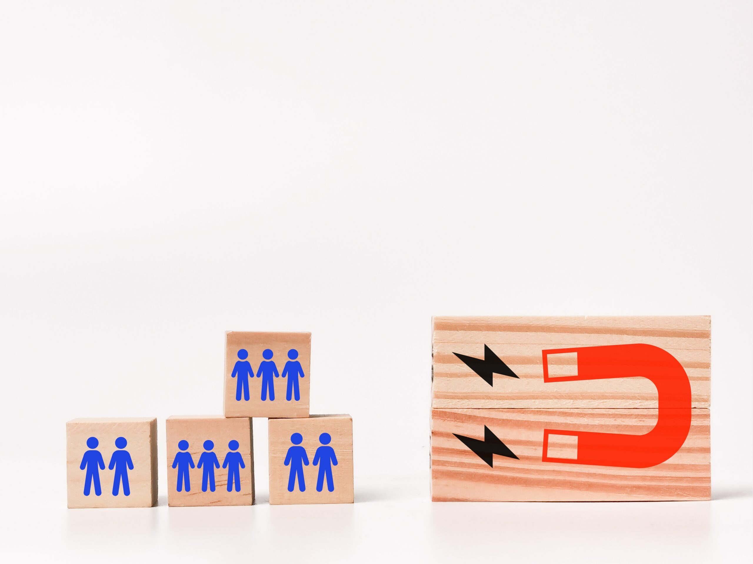 Wooden blocks with magnet and people icons, representing effective customer retention strategies.