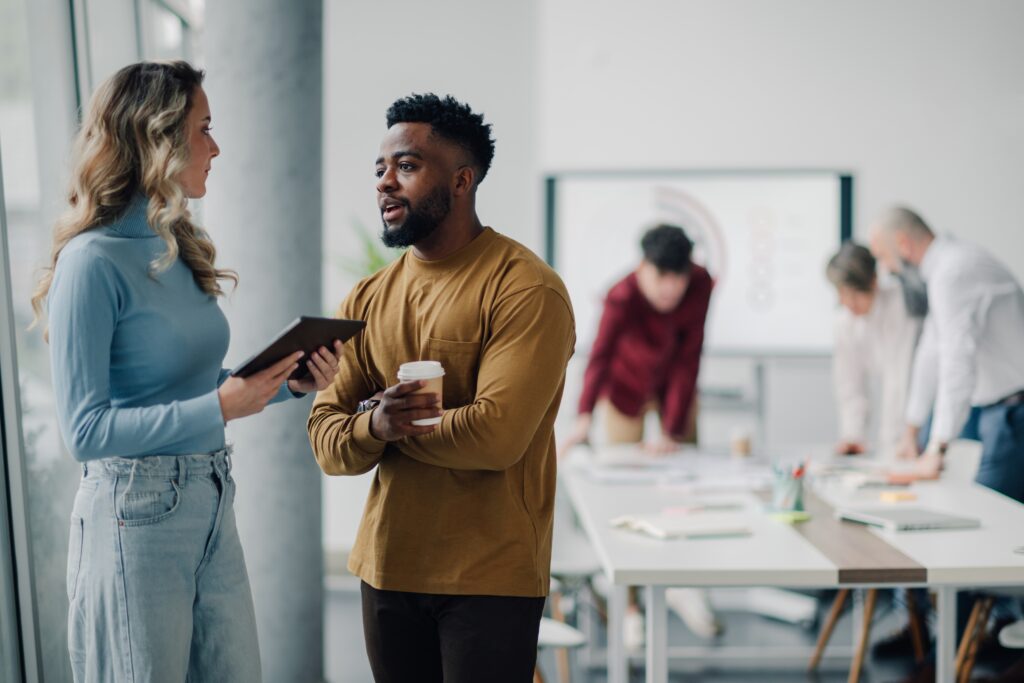 Sales teams engaging in work discussions at the office.