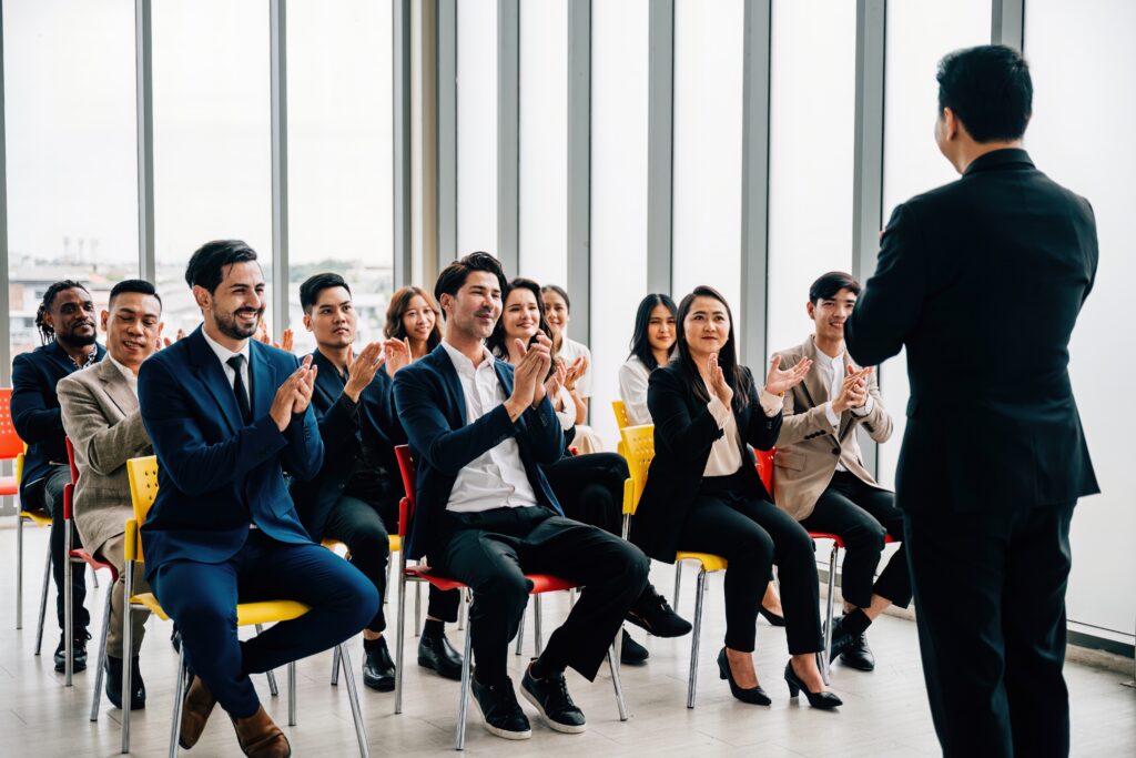 Professionals applauding a speaker during a management leadership skills training session.